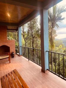 a porch with a fireplace and a bench on a balcony at Misty Haven A-Frame in Kandy