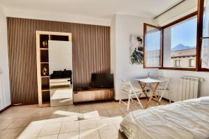 a bedroom with a bed and a table and a television at Bella Aqua Lake in Acquaseria