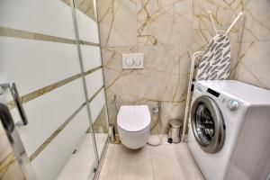 a bathroom with a washing machine and a toilet at Bella Aqua Lake in Acquaseria