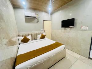a hotel room with a bed and a tv at Hotel Comfy Point - Sec 44 Noida in Noida
