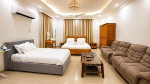 a living room with a couch and a bed at Albazar Residence Salalah in Salalah