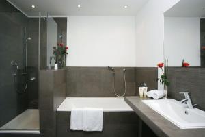 a bathroom with a bath tub and a sink at Hotel Regina in Cologne