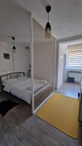 a bedroom with a bed and a yellow rug at Apartment Fortuna in Visoko