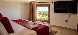 ein Hotelzimmer mit einem Bett und einem Fenster in der Unterkunft Corallo Home Resort in Le Castella