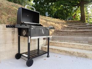 a bbq grill sitting on wheels next to some stairs at Nidus in Aulla