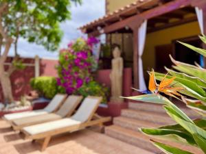 a patio with chairs and flowers on a house at Villa Zen - Tu oasis en el sur de Tenerife in Adeje
