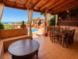 a patio with a table and chairs and a pool at Villa Zen - Tu oasis en el sur de Tenerife in Adeje