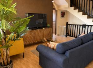 a living room with a blue couch and a tv at Villa Zen - Tu oasis en el sur de Tenerife in Adeje +30 photos