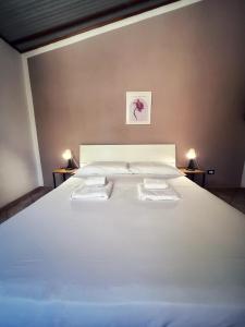 a bedroom with a white bed with two towels on it at Quirino Residence in Gaeta