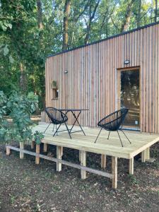 two chairs sitting on a wooden deck in front of a building at Tiny housse in Conne-de-Labarde