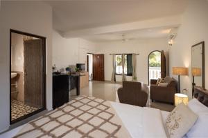 a room with a bed and a living room at Palolem White House in Canacona