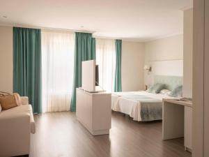 a bedroom with a bed and a television in it at Ona Palmira Paguera in Paguera