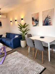 a living room with a blue couch and a table at VN Lux Apartments in Prijevor