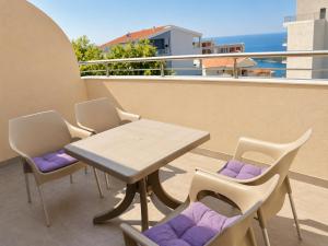 a table and chairs on a balcony with the ocean at VN Lux Apartments in Prijevor