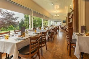 a dining room with tables and chairs and large windows at The Murray Park Hotel in Crieff