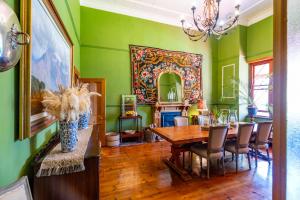 a dining room with green walls and a table and chairs at La Rochelle in Montagu