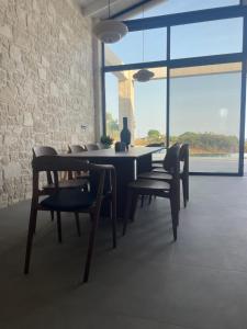 ein Esszimmer mit Tisch und Stühlen und einem großen Fenster in der Unterkunft Villa Yi in Chorafakia