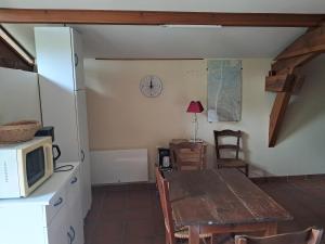a kitchen with a table and a microwave at L'auberge Chris and Chris in Retjons