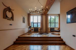 a living room with stairs and a chandelier at Lens Design Hotel in Kazbegi