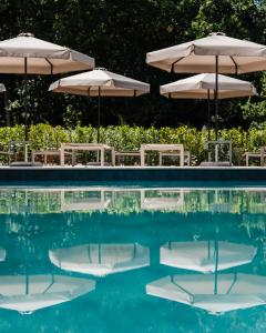 two chairs and umbrellas in a swimming pool at Villa Castiglione in Impruneta