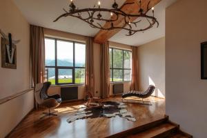 a living room with a chandelier and a wooden floor at Lens Design Hotel in Kazbegi