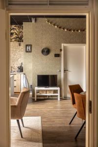 a living room with a television and a table and chairs at Appartement B&B In de Gulde Steur in Deventer