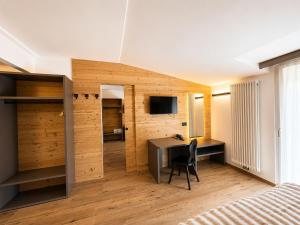 a bedroom with a desk and a room with a bed at Hotel Kapriol in Folgarida