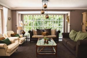 a living room with couches and a coffee table at The Cosy Cottage - Comfort Sauna & Hot Tub in Private Garden in Zeewolde