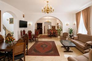 a living room with a couch and a dining room at Queen's Crown Manor in Predeal