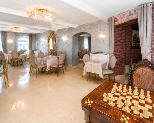 a dining room with tables and chairs and a chessboard at Queen's Crown Manor in Predeal