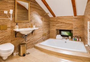 a bathroom with a tub and a sink and a toilet at Queen's Crown Manor in Predeal +51 photos