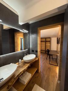 a bathroom with two sinks and a large mirror at Hotel Kapriol in Folgarida +59 photos