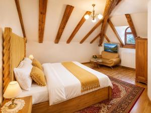 a bedroom with a bed and a chair in a room at Queen's Crown Manor in Predeal