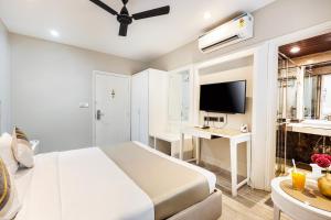 a white bedroom with a bed and a desk at Skon Boutique by Orion Hotels in Delhi