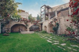 a courtyard of a building with a garden with red flowers at Minia Cave Hotel in Ortahisar