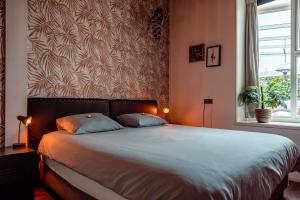 a bedroom with a large bed with two pillows at Appartement B&B In de Gulde Steur in Deventer
