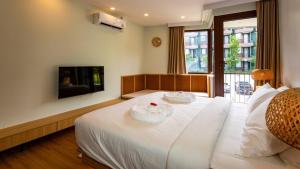 a bedroom with a large white bed with two plates on it at Wing 4206 - Modern Resort Studio Koh Samui in Bophut +13 photos