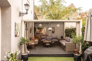 a backyard patio with a couch and a table at Appartement B&B In de Gulde Steur in Deventer