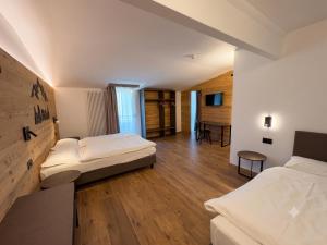 a hotel room with two beds and a table at Hotel Kapriol in Folgarida