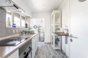 a kitchen with white cabinets and a refrigerator at Casa da Matilde in Estoril +12 photos