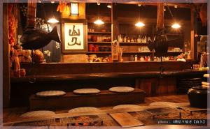 a bar with two stools in front of a counter at Ryokan Yamanoyu in Minamioguni