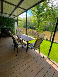 a wooden deck with a table and chairs on it at MAX Dunaj in Trstice +8 photos