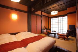 a bedroom with a large bed and a television at Ryokan Yamanoyu in Minamioguni
