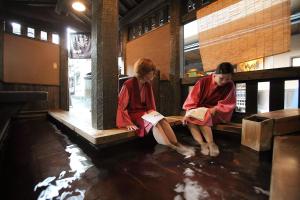 two women sitting on a bench reading books at Ryokan Yamanoyu in Minamioguni