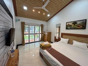 a bedroom with a bed and a flat screen tv at Green Paradise - Trimbakeshwar in Trimbak