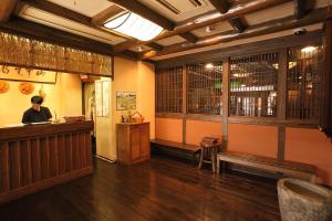 a man standing at the counter of a restaurant at Ryokan Yamanoyu in Minamioguni