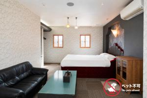 a hotel room with a bed and a couch at ホテルサルビア in Tendo