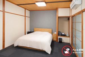 a bedroom with a bed in a room at ホテルサルビア in Tendo