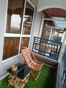 a rocking chair and a table on a balcony at Mura suites homes in Nakuru