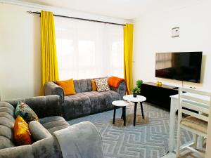 a living room with a couch and a flat screen tv at Mura suites homes in Nakuru +9 photos